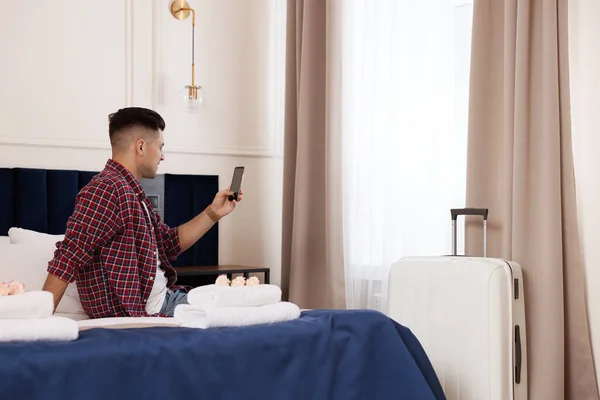 Hombre Guapo Usando Teléfono Inteligente Cama Habitación Hotel — Foto de Stock