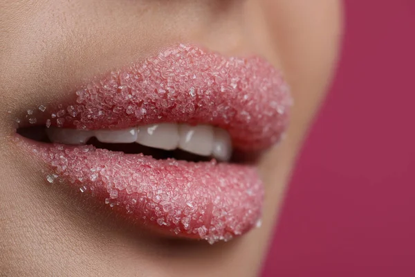 ピンクの背景に砂糖で覆われた美しい唇を持つ若い女性は クローズアップ — ストック写真