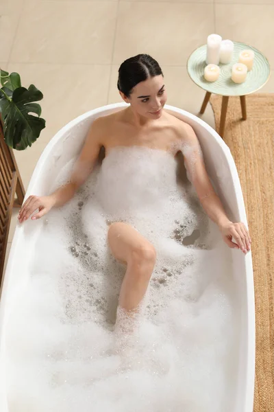 美しい若い女性は家で泡風呂を取ります 上のビュー — ストック写真