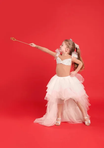 赤い背景にダイエムと魔法の杖を持つ妖精のドレスのかわいい女の子 — ストック写真