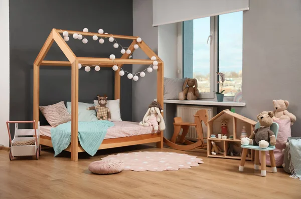 家やおもちゃの形をした木製ベッド付きのスタイリッシュな子供部屋のインテリア — ストック写真