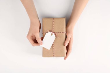 Beyaz arkaplanda etiketli bir pakete sarılı kadın, üst görünüm