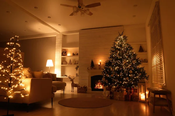 装饰华丽的客厅靠近壁炉的美丽圣诞树和礼品盒 — 图库照片