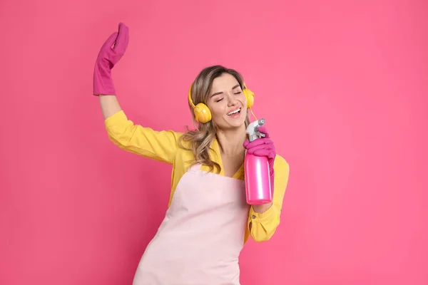 Piękna Młoda Kobieta Słuchawkami Butelką Detergentu Śpiewająca Różowym Tle — Zdjęcie stockowe