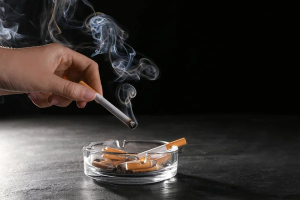 Mujer Sosteniendo Cigarrillo Humeante Sobre Cenicero Vidrio Mesa Gris Sobre —  Fotos de Stock