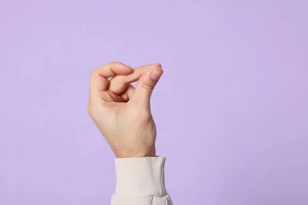 男人在紫罗兰的背景上打响了手指 手部的特写 案文的篇幅 — 图库照片