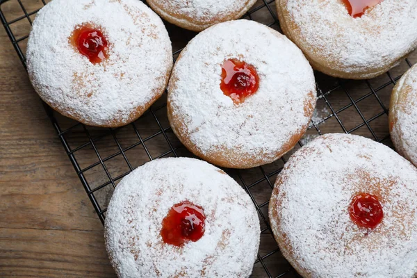 stock image Many delicious donuts with jelly and powdered sugar on wooden table, top view