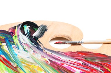 Beyaz arka planda boyalı ve fırçalı palet, yakın plan. Sanatçı ekipmanı