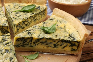 Tahtaya ıspanaklı turta kesin, yakın plan.