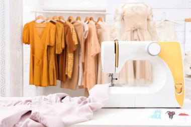 Terzi atölyesindeki kumaşlı modern dikiş makinesi.