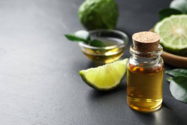 Karanlık masanın üzerinde bir şişe bergamot yağı. Metin için boşluk