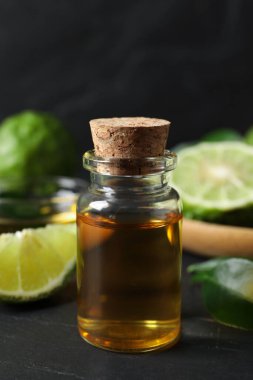 Bir şişe bergamot esaslı yağı karanlık masanın üzerinde, yakın plan.