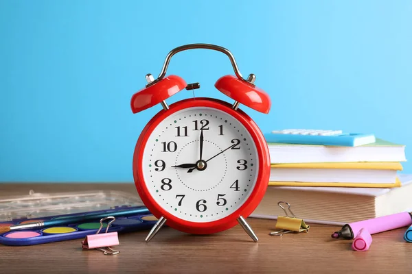 Red Alarm Clock Different Stationery Wooden Table Light Blue Background — Stock Photo, Image