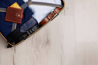 Tahta yüzeyde iş gezisi eşyalarıyla dolu bavul, üst manzara. Metin için boşluk