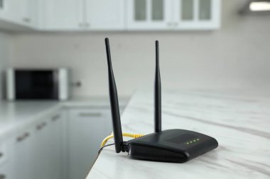 Modern Wi-Fi yönlendirici mutfaktaki beyaz mermer masada.