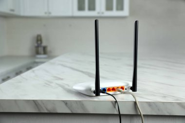 Modern Wi-Fi yönlendirici mutfaktaki beyaz mermer masada.