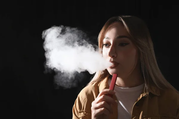 Mladá Žena Pomocí Elektronické Cigarety Černém Pozadí — Stock fotografie