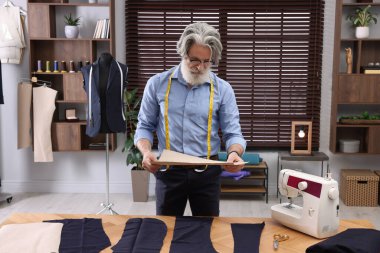 Atölyenin yakınında çizim yapan profesyonel bir terzi.