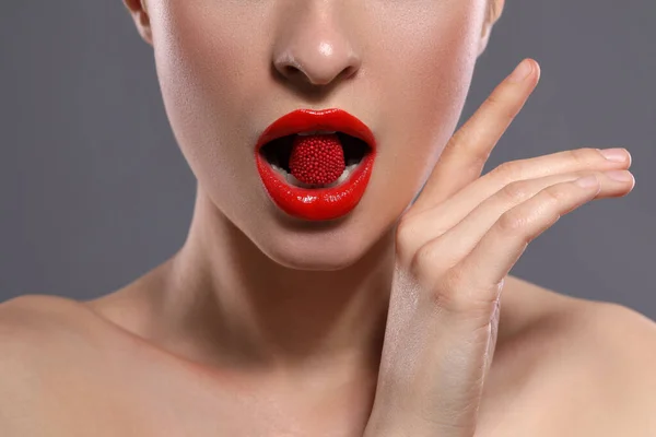 Giovane Donna Con Labbra Rosse Trucco Mangiare Caramelle Sfondo Grigio — Foto Stock