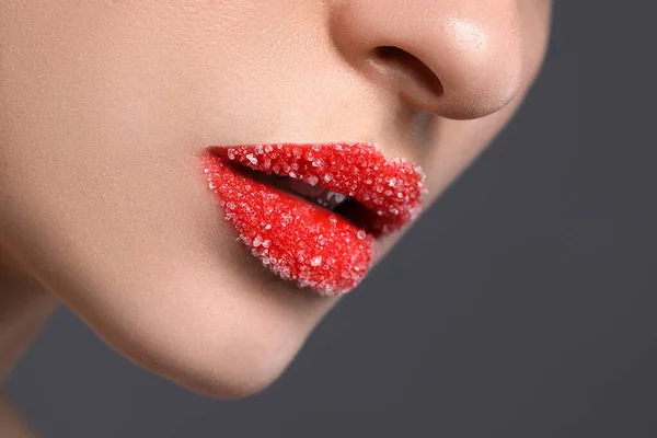 美しい唇を持つ女性は灰色の背景に砂糖で覆われ クローズアップ — ストック写真