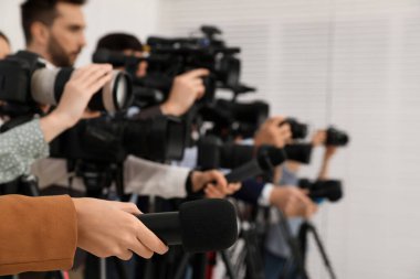 Kameralı bir grup gazeteci içeride resmi kişiyi bekliyor, yakın çekim