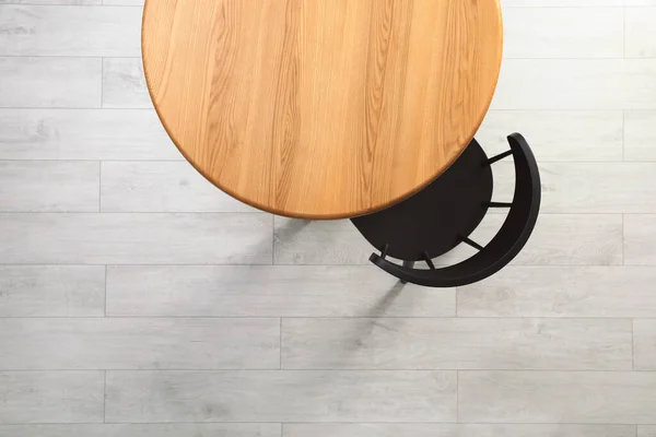 Empty wooden table and chair indoors, top view. Stylish furniture