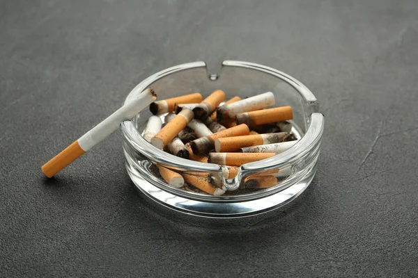 Γυάλινο Τασάκι Γεμάτο Αποκόμματα Τσιγάρων Γκρι Τραπέζι — Φωτογραφία Αρχείου