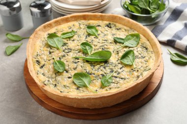 Açık gri masada nefis ev yapımı ıspanaklı turta.