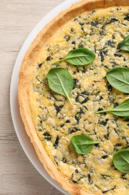 Beyaz ahşap masada nefis ev yapımı ıspanaklı turta.