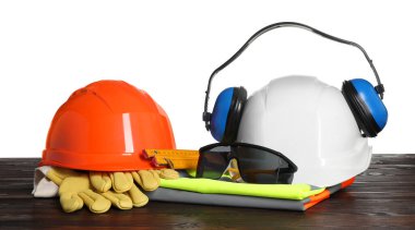 Beyaz arkaplana karşı ahşap masa üzerinde güvenlik ekipmanları ve araçlar ile ayarlayın