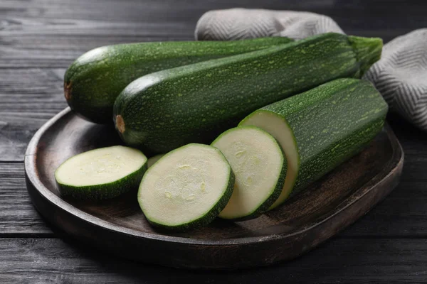 Ganze Und Geschnittene Reife Zucchinis Auf Schwarzem Holztisch — Stockfoto