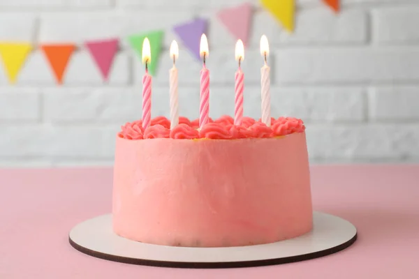 可爱的本托蛋糕 配上美味的奶油和粉红桌上点燃的蜡烛 — 图库照片