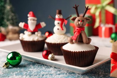 Mavi masadaki farklı güzel Noel kekleri. Şenlikli ve karlı.