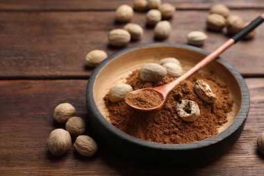 Nutmeg tozu ve tohumlar ahşap masada.