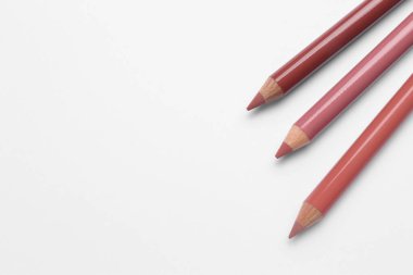 Beyaz arka planda farklı dudak kalemleri, üst manzara. Kozmetik ürünü