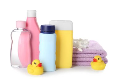 Beyaz arka planda bebek kozmetik ürünleri, havlular, pamuklu bezler ve lastik ördekler.