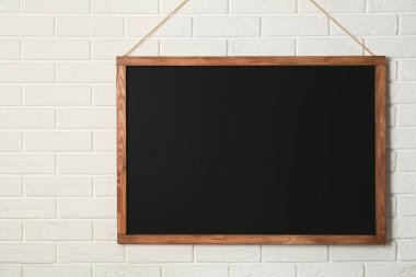 Beyaz tuğla duvarda asılı temiz siyah karatahta