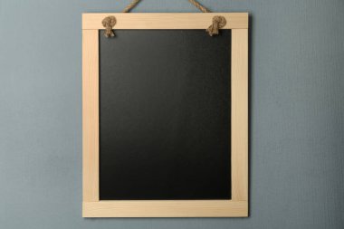 Gri duvarda asılı temiz, küçük siyah karatahta