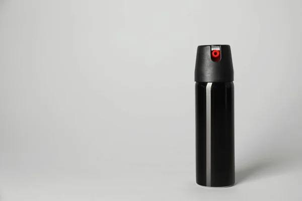 Bottle of gas pepper spray on light grey background. Space for text