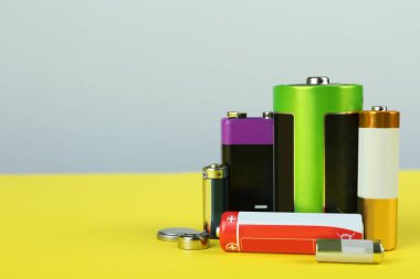 Renk arkaplanı üzerindeki farklı pil türleri, metin için boşluk