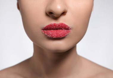 Dudakları şekerle kaplı genç bir kadın arka planda, yakın plan