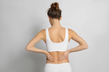 Açık gri arka planda acı çeken bir kadın.