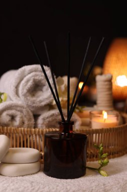Aromatik kamış oda spreyi, rulo havlular ve masadaki spa taşları