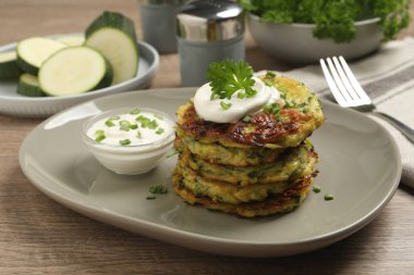 Ahşap masada servis edilen ekşi kremalı lezzetli kabaklı börek.