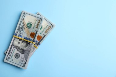 Açık mavi arka planda bir tomar banknot, üst manzara. Metin için boşluk