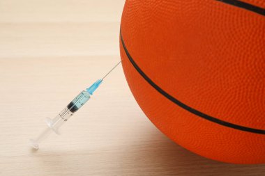 Tahta masada şırıngalı basketbol topu, yakın plan. Doping kavramı