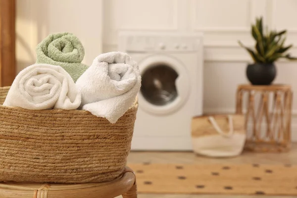 在洗衣房的凳子上放有干净的滚筒毛巾的篮子 案文的篇幅 — 图库照片