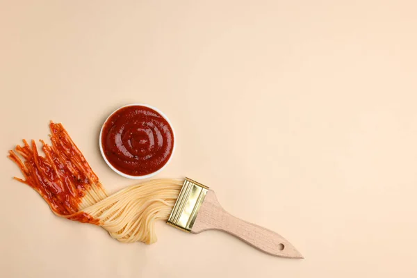 Pintura Pincel Con Espaguetis Sumergidos Ketchup Sobre Fondo Beige Acostado — Foto de Stock