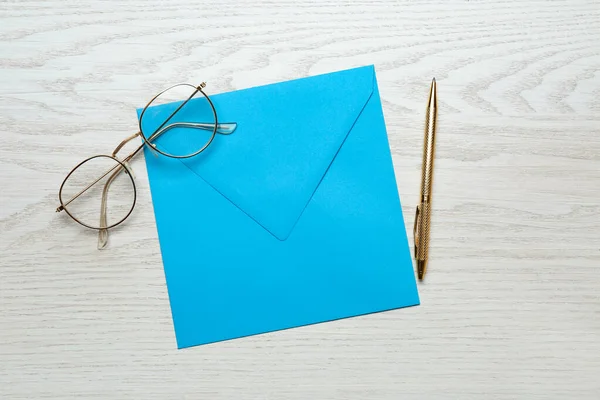 Envelope Azul Esverdeado Óculos Caneta Sobre Mesa Madeira Branca Flat — Fotografia de Stock