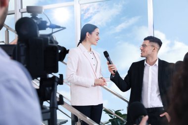 Mutlu iş kadını içeride gazetecilerle konuşuyor.